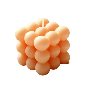 Candela a cubo a bolle arancione chiaro minimalista con design geometrico su sfondo bianco