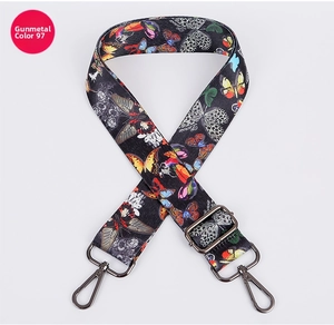 Close-up of adjustable fabric bag strap with colorful butterfly pattern and gunmetal hooks