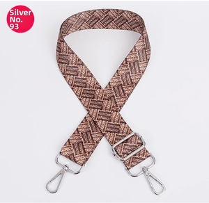 Detail of adjustable woven shoulder strap with brown pattern and silver metal hooks