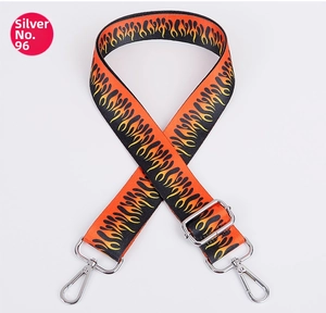 Close-up of adjustable woven purse strap with orange flame pattern and silver metal hooks