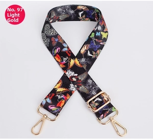 Detail view of adjustable bag strap with butterfly pattern and light gold lobster clasps