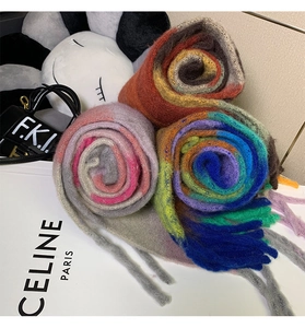 Close-up of three rolled-up colorful plaid cashmere scarves with soft texture and fringes