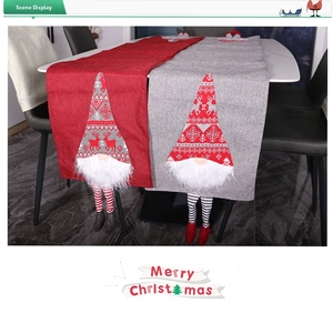 Detail view of red and gray Christmas table runners with hanging gnome legs decoration