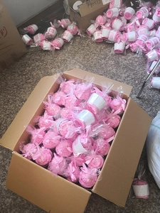 Bulk quantity of 120 pink coral fleece socks neatly packed in a storage shipping carton