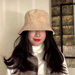 Beige faux suede bucket hat shown with high-neck sweater for a trendy autumn look
