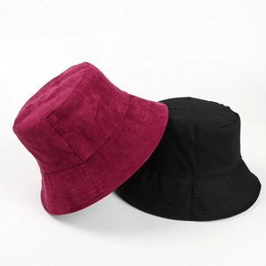 Flat lay of suede burgundy and black cotton bucket hats showing fabric texture and stitching