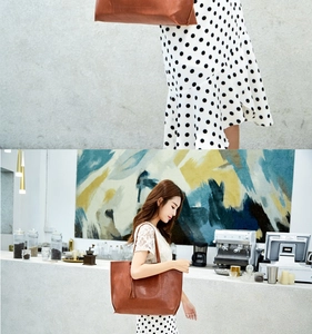 Brown vintage oil wax leather bucket bag shown held by model with fringe detail
