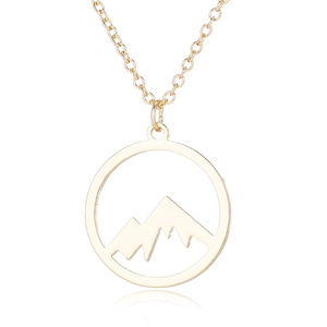 Macro shot of gold hollow circular mountain range pendant necklace with reflective finish