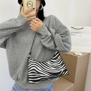 Fashionable zebra print shoulder bag for women with black strap and gold metal hardware
