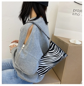 Close-up of zebra pattern shoulder bag with sleek zipper detail and minimalist strap
