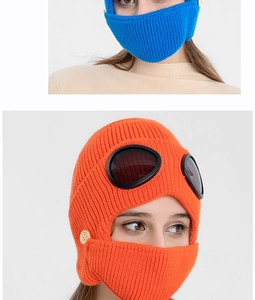 Close-up of winter knit hat featuring goggles and a removable face mask with wooden buttons