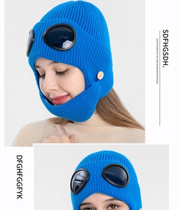 Detail of blue knitted aviator hat with goggles and decorative side buttons