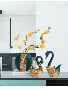 Detail van luxe keramische zwaanornamenten met gouden accenten en diepgroen glazuur