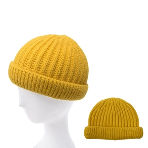 Detail of ginger yellow knitted beanie showing thick texture and folded cuff style