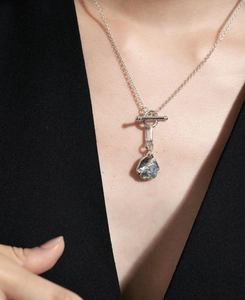 Close-up of 925 sterling silver necklace with textured round pendant and toggle clasp