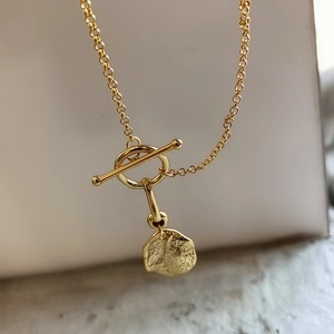 Detailed close-up of a 925 silver golden toggle clasp necklace with a hammered pendant