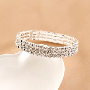 Elegant silver multilayer rhinestone bracelet displayed on a heart ceramic plate