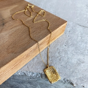 Detailed view of 925 sterling silver hammered rectangle pendant with gold finish