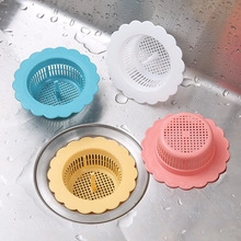 Macro view of 4 colorful sink drain strainers in blue white yellow and pink plastic