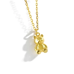 Close-up of golden necklace featuring a 3D bear pendant with a classic cross chain link