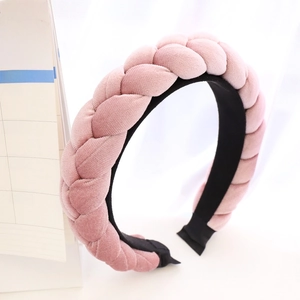 Detail view of pink braided velvet headband showing soft texture and twisted braid design