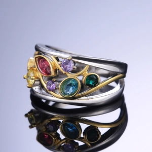 Macro shot of a hollowed vintage ring with colorful gemstones and gold vine detail