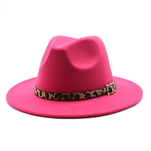 Close-up of rose red fedora hat featuring a leopard print belt and gold buckle