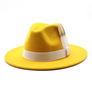 Détail d'un chapeau fedora en laine jaune avec ruban blanc et plumes décoratives