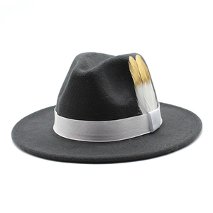 Détail du chapeau fedora en laine gris foncé avec ruban blanc et plume dorée