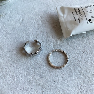 Detail of minimalist 925 silver rings with hollow floral patterns and twisted design