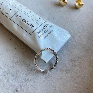 Detail view of a 925 sterling silver woven rope ring with polished finish and open design