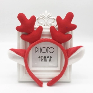 Cute red plush reindeer antler headband for Christmas decor shown on a white background