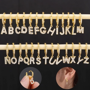 Detailed display of 26 gold alphabet earrings with micro-paved zircons on black background