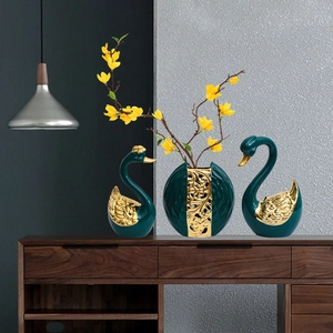 Nordic emerald swan sculpture set with golden floral details and vase on a luxury console