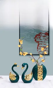 Détail de sculptures de cygnes vert foncé et vase doré pour une décoration de luxe