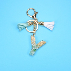 Detail of letter Y resin keychain with gold foil flakes and colorful tassels