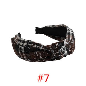 Detail of vintage brown plaid headband with a stylish knot and thick woven fabric texture