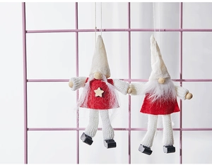 Close-up of handmade felt Christmas gnomes with knitted hats and wooden star details