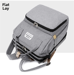 Side view of gray multifunctional diaper bag showing layered zippers and fabric texture