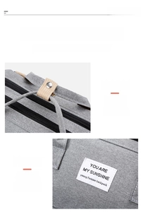 Detail of grey diaper bag with reinforced stitching and stroller attachment snaps