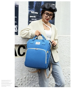 Close-up of stylish blue diaper backpack with "YOU ARE MY SUNSHINE" label detail