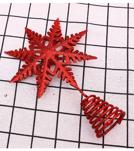 Close-up of red glitter snowflake Christmas tree topper with a spiral metal base