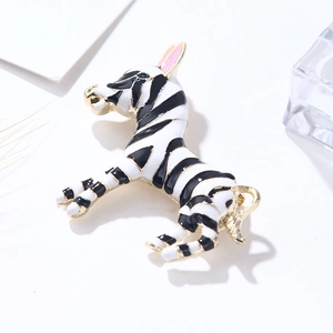 Detailed macro view of zebra enamel brooch with black white patterns and gold plating