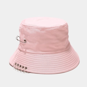 Détail du chapeau bob rose avec cinq anneaux métalliques et une épingle de style punk