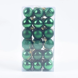 Detail of green Christmas balls in various finishes like matte and glitter in a box