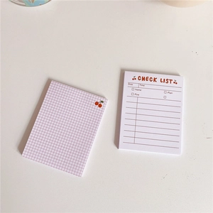 Detailed view of pink grid memo pad and cherry themed daily check list stationery