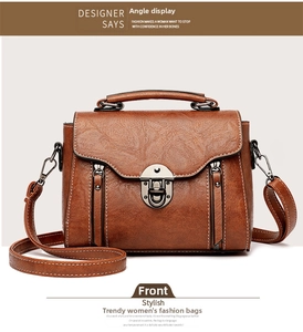Detailed front view of brown textured leather crossbody bag with silver hardware and stitching