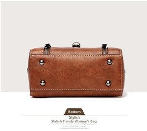 Detail view of the brown leather handbag base with protective metal studs and neat stitching