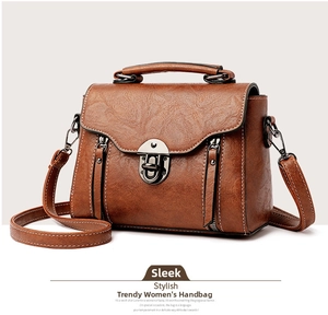 Detail view of vintage brown leather handbag featuring lychee texture and metal buckle