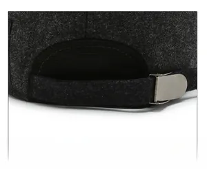 Close-up of adjustable metal buckle and textured grey fabric on back of the winter cap